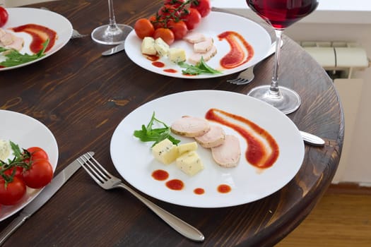 A beautifully plated gourmet meal featuring chicken, cheese, and cherry tomatoes, perfect for fine dining.