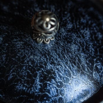 A captivating closeup photo shows a stunning silver ring on a textured dark surface, highlighting its beauty