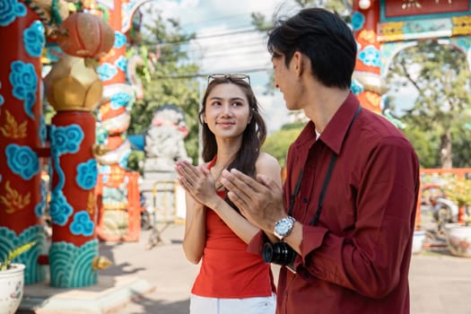 A couple cherishes the vibrant celebrations of Chinese New Year at a stunning temple embracing joy and tradition.
