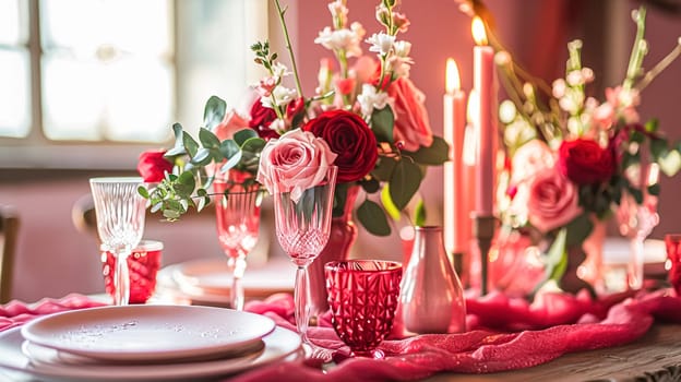 Festive table setting with candles and arrangement of beautiful red flowers. Holiday concept. High quality photo