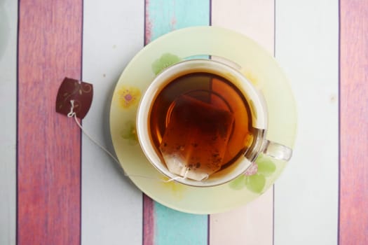 A steaming, warm cup of aromatic tea beautifully displayed on a vibrant, colorful table
