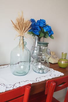 Charming vases with golden wheat and blue flowers elegantly placed on a rustic table