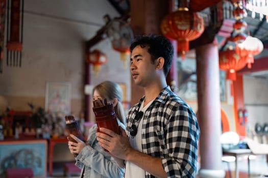 A couple engages in a cultural exploration at a vibrant temple deepening their travel experience through local traditions.