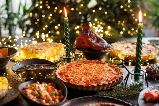 Festive table setting with Christmas decorations and burning candles in the dining room, cozy romantic Christmas in the evening atmosphere