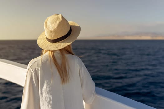 Elegant sexy woman in white dress standing near railings and looking on sunset. Like yacht style. High quality photo