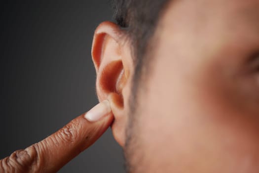 young man having ear pain touching his painful ear