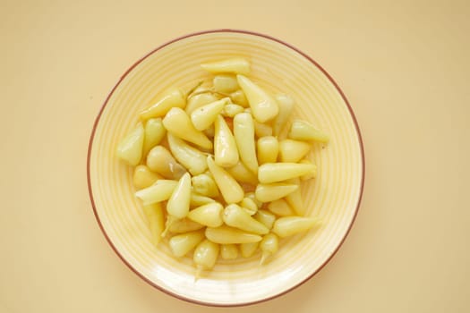 Top View of Pickled Vegetables in a Yellow Ceramic Bowl on Table,