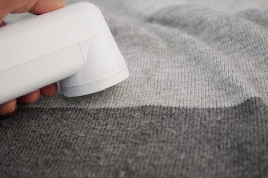 Efficient Fabric Care With White Lint Remover on Grey Sweater/