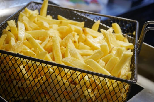 Enjoy a serving of crispy golden French fries that are beautifully presented in a metal basket
