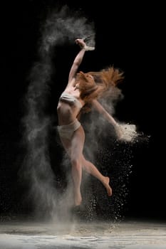 Slim blonde in bandage jumping in white dust cloud full-length shot