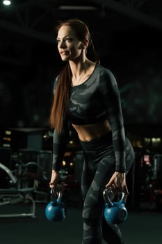 Slim girl in sportswear exercising with dumbbells view