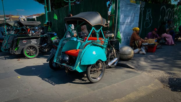 pedicab or rickshaw or locals calls it becak with a canopy is parked on a sunny street, reflecting a vibrant urban scene. The vehicle features a padded seat and unique design