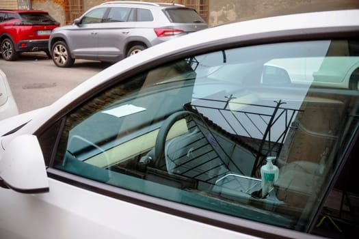 Cremona, Itally - October 6th 2024 White tesla model 3 long range dual motor parked on the street with a bottle of hand sanitizer visible on the central console