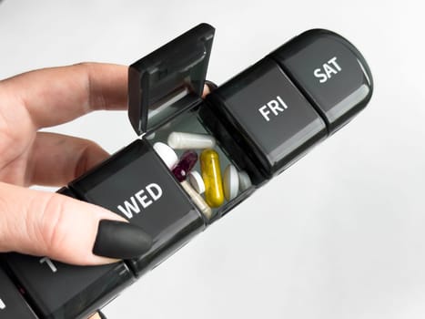 Weekly pill organizer with vitamins and supplements for daily health management.