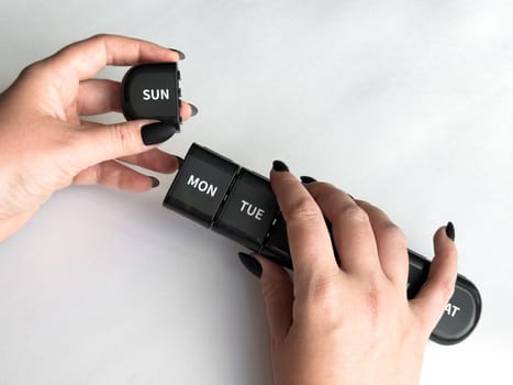 Weekly pill organizer with days of the week labels for medication management.