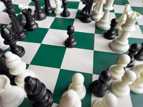 Strategic chessboard with black pawn surrounded by chess pieces.