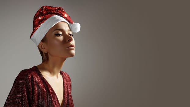 Fashion woman in Christmas hat, Red Style with sparkly Clothes. Glamour xmas Girl.