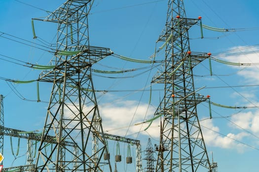High voltage towers with sky background. Power line support with wires for electricity transmission. High voltage grid tower with wire cable at distribution station. Energy industry, energy saving.