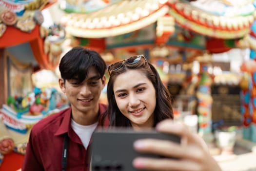 Happy travelers enjoying Chinese New Year festivities with colorful lanterns and traditional decorations in a lively cityscape.