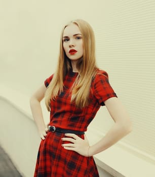Portrait beautiful blonde woman wearing red checkered dress in city
