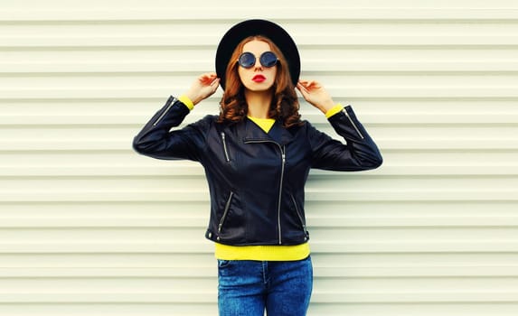 Fashionable portrait of stylish woman model posing in black rock style jacket on white background