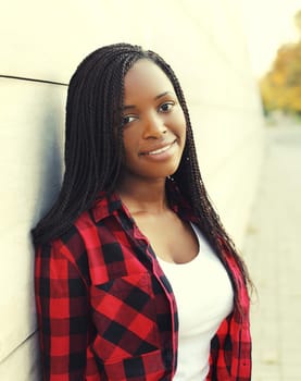 Portrait of beautiful happy young african woman with dreadlocks hair in city