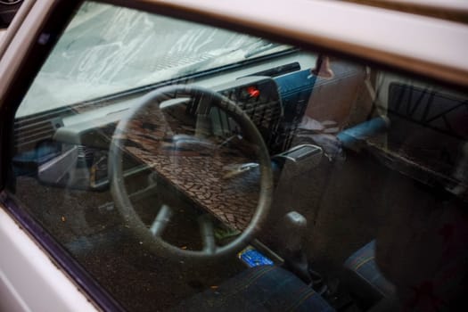 Cremona, Itally - October 6th 2024 Viewing the interior of a parked 1980s white fiat panda 4x4 sisley through the window, with a focus on the steering wheel and dashboard
