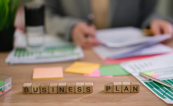 An illustration showing the process of creating a detailed business plan, with papers and notes on an office desk