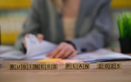An engaged individual is reviewing essential documents for a comprehensive business plan aimed at 2025