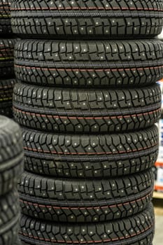 Sale of car tires for sale in the store. Many new winter tires lie horizontally. There is space for text