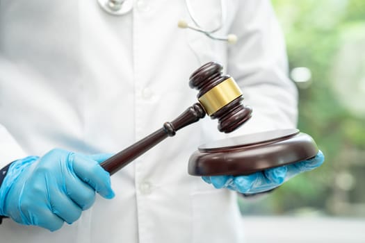 Doctor holding judge gavel, forensic medicine, medical law and crime justice concept.