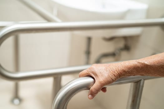 Asian elderly woman patient use toilet bathroom handle security in nursing hospital, healthy strong medical concept.