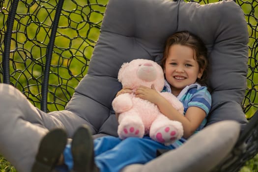 Portrait of a little girl hugging a teddy bear outdoors