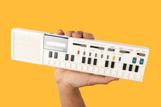 Male hand holding a 90s synth and calculator isolated