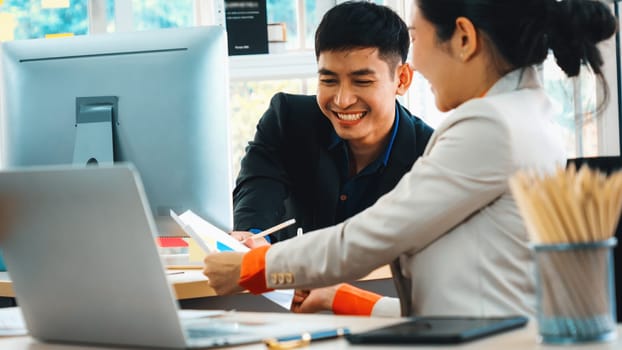 Two business people talk project strategy at office meeting room. Businessman discuss project planning with colleague at modern workplace while having conversation and advice on financial report. Jivy