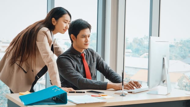 Two business people talk project strategy at office meeting room. Businessman discuss project planning with colleague at modern workplace while having conversation and advice on financial report. Jivy