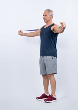 Full body length shot athletic and sporty senior man with fitness resistance band on isolated background. Healthy active physique and body care lifestyle after retirement. Clout