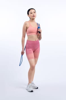 Young energetic asian woman in sportswear with jumping or skipping robe posing portrait in studio shot on isolated background. Cardio exercise tool and healthy body care lifestyle. Vigorous