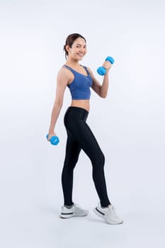 Vigorous energetic woman doing dumbbell weight lifting exercise on isolated background. Young athletic asian woman strength and endurance training session as body workout routine.