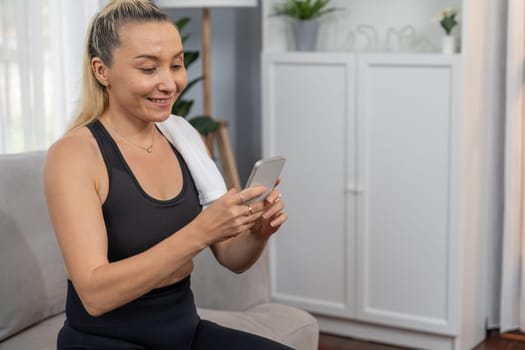 Active and sporty senior take selfie with smartphone after finishing home workout exercise. Healthy and fit body lifestyle for pensioner after retirement workout exercising at home. Clout