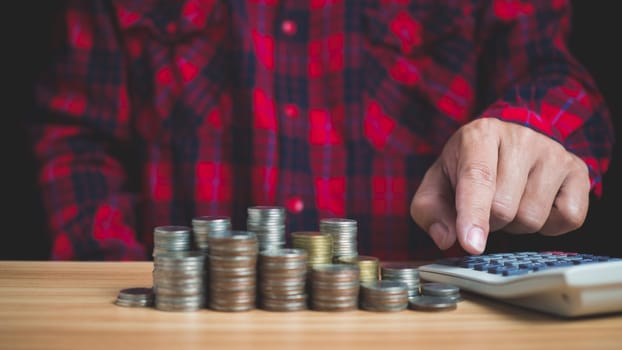 Businessman using a calculator to manage business accounts, Calculate saving money for future rate of return, retirement fund, business investment finance accounting concept.
