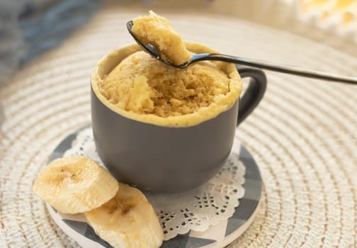 selective focus. homemade Portioned Banana bread mugcake in small mugs. Easy sweet baking in the microwave idea, With fresh bananas, nuts. Muffin with banana slices cooked in a mug. copy space.