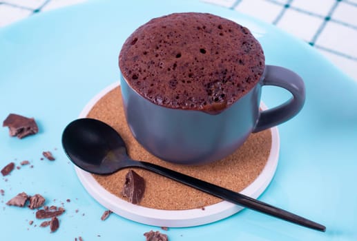 mugcake is microwaved. Homemade cupcake in a mug is on a plate. Chocolate brownie mug cake. Easy cooking concept, microwave baking. muffin chocolate. High quality photo