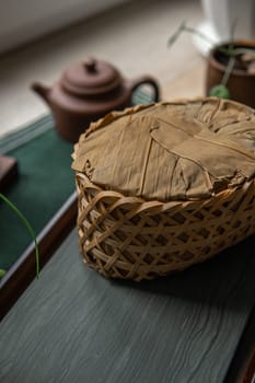 A beautifully woven basket enhances a serene tea setting featuring a charming teapot alongside lovely natural elements