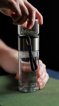 A hand skillfully using a modern spice grinder over a glass container, showcasing the art of culinary creativity