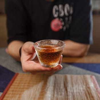 A person is joyfully holding a glass filled with a bubbly and sparkling drink, creating a warm and inviting atmosphere