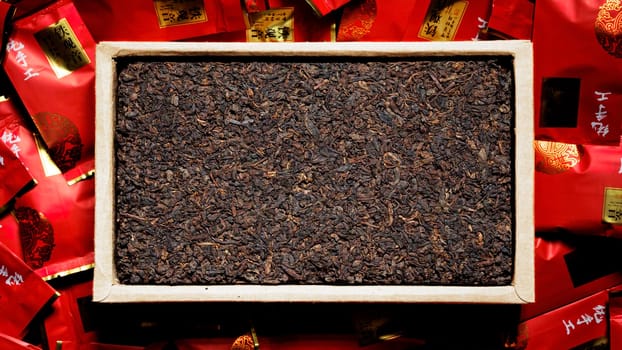 An elegant display of loose leaf teas in a crafted wooden tray, with colorful, vibrant packaging around them
