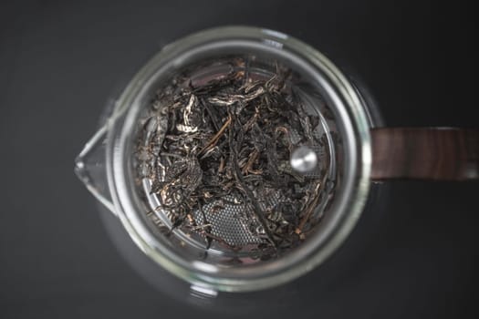 A vibrant display of dried loose leaf tea, showcasing its unique texture and detail in a glass container