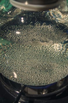 A mesmerizing closeup of bubbling water trapped beneath a clear glass lid, vividly showcasing its movement and texture