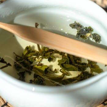 A peaceful and serene moment unfolds as green tea leaves slowly steep in hot water, releasing their essence
